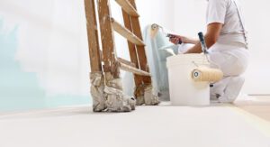 painter at work with a roller, bucket and scale